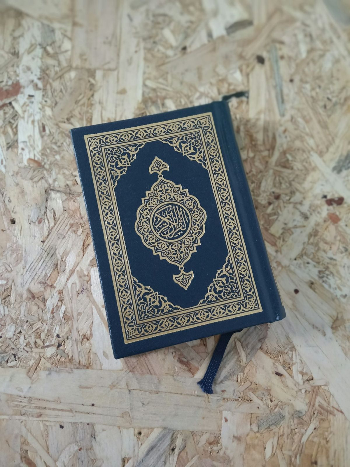 Livre du Coran fermé posé au sol en bois